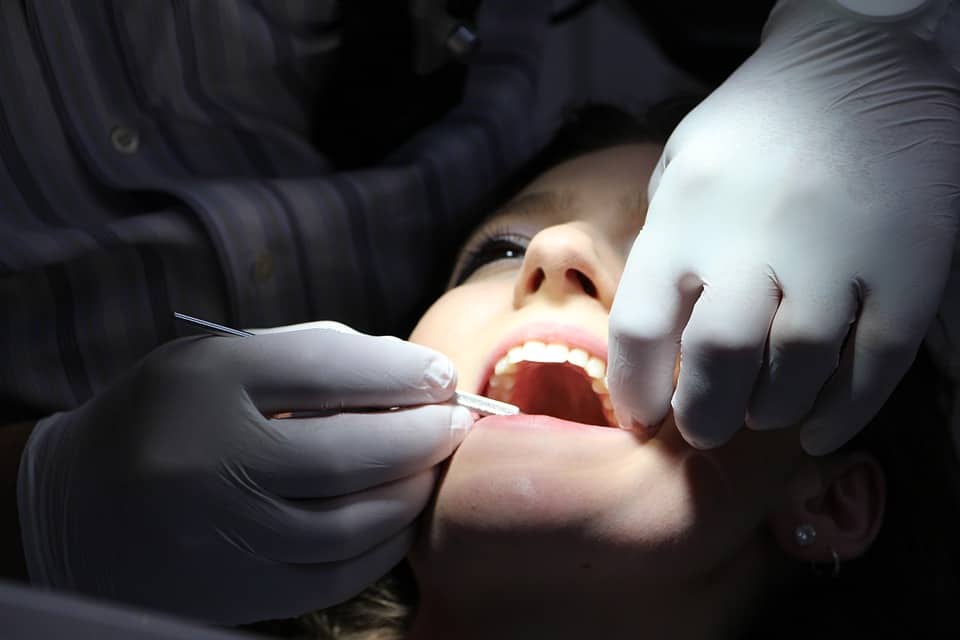 Tooth Extraction Raynes Park - The Image Captures A Dental Procedure At Beverley Dental In Raynes Park, Where A Patient Is Undergoing A Tooth Extraction. The Dentist, Wearing Gloves For Hygiene And Safety, Carefully Uses Dental Instruments To Extract A Tooth From The Patient's Mouth. The Patient's Open Mouth And Visible Teeth Indicate The Meticulous Nature Of The Procedure. This Scene Exemplifies The Clinic's Expertise In Providing Essential Dental Care, Such As Extractions, To Address Dental Issues And Ensure The Patient's Oral Health. Beverley Dental Is Committed To Offering Professional And Compassionate Care, Ensuring Patient Comfort And Successful Outcomes During Such Procedures.